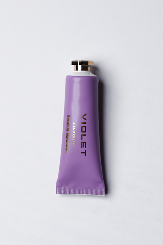 A purple tube of violet hand cream with white text labeling by Atyab Al Marshoud .